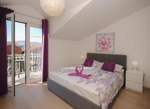 una camera da letto con un letto con un nastro rosa sopra di Red Sunset Apartments a Kaštela (Castelli)