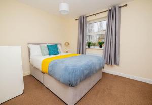 um quarto com uma cama e uma janela em Charming 4-bedroom home in Corby em Great Oakley
