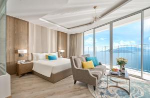 um quarto de hotel com uma cama e uma cadeira em Oceanfront Panorama Nha Trang em Nha Trang
