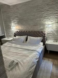 a bedroom with a large bed and two night stands at AKOYA APARTMENTS Bianco in Koszalin