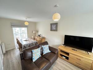 a living room with a couch and a flat screen tv at Admirals Cottage in Filey