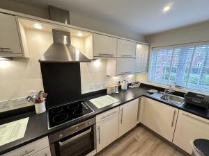a kitchen with white cabinets and a stove top oven at Admirals Cottage in Filey