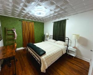 een slaapkamer met een bed, een bureau en groene muren bij Augi's Den. Close to Masters. Modern. Fun in Augusta