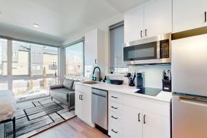a kitchen with white cabinets and a large window at Marion Place in Seattle