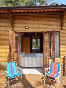 2 sedie sedute su un portico con una camera da letto di Casa Mohini a Teresópolis