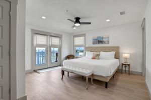 a white bedroom with a large bed and windows at Seaside Harbor Retreat in Mexico Beach