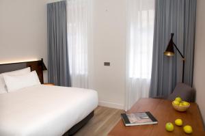 una habitación de hotel con una cama y una mesa con una mesa en Prisma Suites, en Salamanca