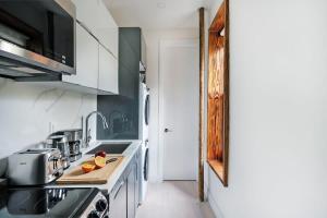 uma cozinha com armários brancos e uma bancada em 48-1FE Brand New 1BR Prime hell's kitchen WD in unit em Nova Iorque