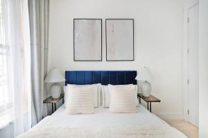 a bedroom with a blue bed with white pillows at 48-1FE Brand New 1BR Prime hell's kitchen WD in unit in New York