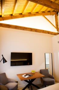 a living room with a tv and a table at Prisma Suites in Salamanca