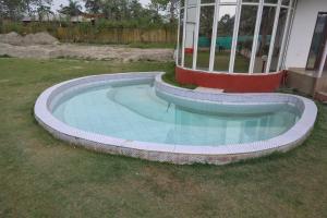 a small swimming pool in a yard next to a house at NBR Resort in Noida