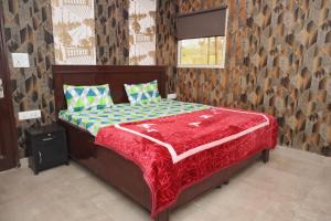 a bedroom with a bed with a red comforter at NBR Resort in Noida