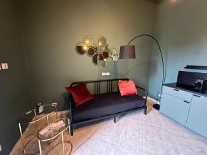 a living room with a black couch and red pillows at Bari Holiday Garibaldi 74 in Bari