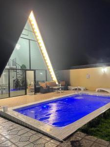 a large blue swimming pool in front of a building at Gabala Twin A Frame Villas in Gabala