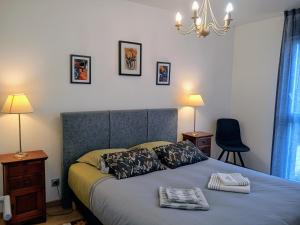 ein Schlafzimmer mit einem Bett mit zwei Handtüchern darauf in der Unterkunft Villa 8 pers proche hypercentre parking gratuit in Vannes