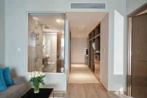 a hallway leading to a bathroom with a walk in shower at Oceanfront Panorama Nha Trang in Nha Trang