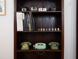 un estante de libros con dos teléfonos pasados de moda. en Filippo's home in Villanova, en Cagliari