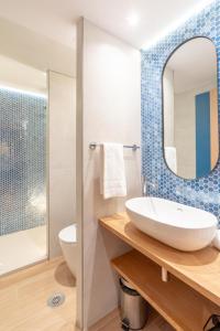 a bathroom with a sink and a mirror at Serennia Cest Apartamentos Arc de Triomf in Barcelona