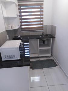een kleine keuken met een spoelbak en een magnetron bij 17 driffield road in East London