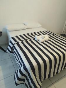 een bed met een zwart-wit gestreepte deken bij 17 driffield road in East London