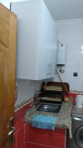 a kitchen with a counter with a sink and a stove at Apartment 20m from Martil beach in Tetouan