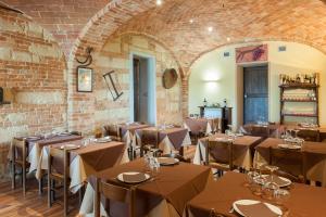 una stanza con tavoli e sedie in un muro di mattoni di Agriturismo Le Tre Rose - Cantina Zanello a Rosignano Monferrato
