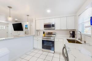 uma cozinha com armários brancos e um forno com placa de fogão em Casa Beach Club em Sarasota