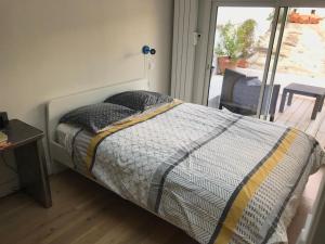 a bedroom with a bed and a table and a window at Maison Surf & Nature à Hendaye in Hendaye