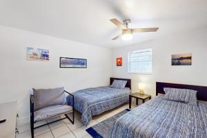 1 dormitorio con 2 camas, silla y ventilador de techo en Casa Beach Club, en Sarasota