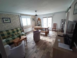 uma sala de estar com um sofá e uma mesa em Les Loges Farm em Le Breuil-sous-Argenton