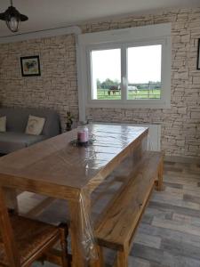 uma mesa de madeira numa sala de estar com uma janela em Les Loges Farm em Le Breuil-sous-Argenton