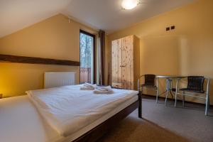 sypialnia z łóżkiem, stołem i krzesłami w obiekcie Villa Vesperia w mieście Ižipovce