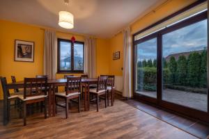 une salle à manger avec une table, des chaises et une grande fenêtre dans l'établissement Villa Vesperia, à Ižipovce