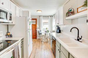 a kitchen with white cabinets and a dining room at Pet-Friendly Watertown Home about 1 Mi to Downtown! in Watertown