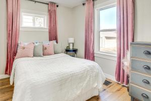 a bedroom with a bed with pink curtains and a window at Pet-Friendly Watertown Home about 1 Mi to Downtown! in Watertown