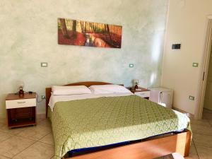1 dormitorio con 1 cama con colcha verde en Salento Perla, en Salve