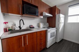 a small kitchen with a white refrigerator and a microwave at Motel Deblois in Sainte-Anne-de-Beaupré