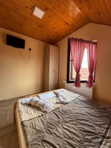 um quarto com uma cama grande e uma janela em Fruškogorska Lugarnica em Mala Remeta
