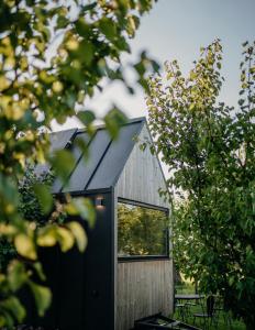 a small house with a black roof and a window at AIVA Glamping in Partizánske