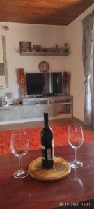- une bouteille de vin sur une table avec 2 verres à vin dans l'établissement Vikendica Popović, à Doboj