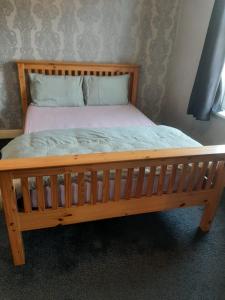 uma cama de madeira com uma estrutura de madeira num quarto em 4 Bedroom Holiday House in lenton em Nottingham