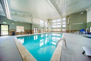 een groot zwembad met blauw water in een gebouw bij Hi Country Haus Haven in Winter Park