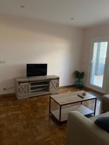 a living room with a tv and a table at Apartamento en A Coruña - Cuatro Caminos centro ciudad in A Coruña