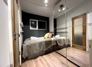 - une chambre avec un lit et un miroir dans l'établissement Great 1 bed flat London/Chiswick, à Londres