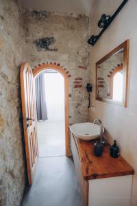 ein Badezimmer mit einem Waschbecken und einer Holztür in der Unterkunft 1881 HALİL EFENDİ OTEL in Alacati