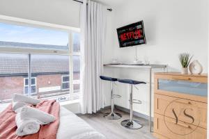 1 dormitorio con 1 cama, TV y ventana en Gorgeous Longton Studio 2a en Stoke on Trent