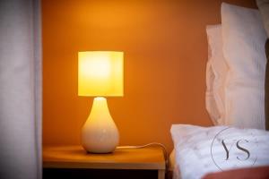 una lámpara sentada en una mesa junto a una cama en Gorgeous Longton Studio 2e en Stoke on Trent