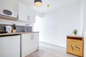 a kitchen with white cabinets and a counter top at Gorgeous Longton Studio 1e in Stoke on Trent