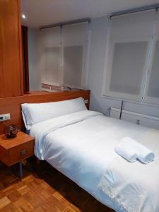 a bedroom with two beds and a table and a window at Apartamento en A Coruña - Cuatro Caminos centro ciudad in A Coruña