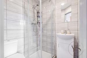 baño blanco con ducha y lavamanos en Gorgeous Longton Studio 2d en Stoke on Trent